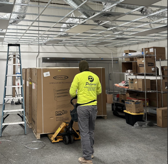 Construction working moving large box with pallet mover