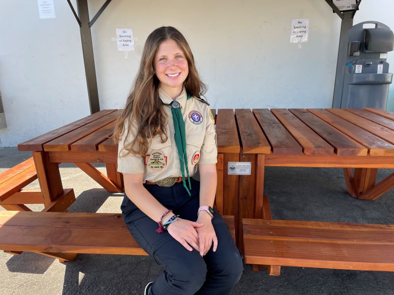 Eagle Scout, Ysabel Brenner, seated at her completed table project